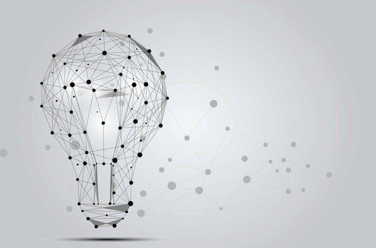 Wireframe lightbulb made of black nodes and lines, with a fading network pattern to the right, on a light gray background.